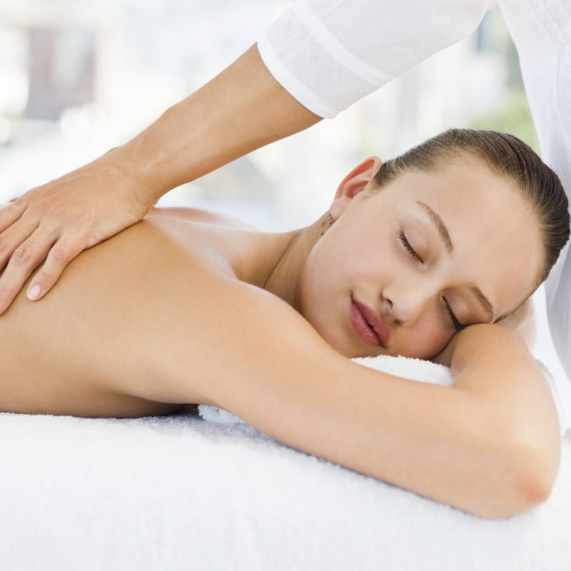 Relaxed pretty young woman receiving back massage